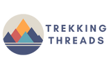 Logo for Trekking Threads featuring stylized, overlapping mountain shapes in blue, orange, and red inside a beige circle, with the brand name in bold, blue uppercase letters to the right.